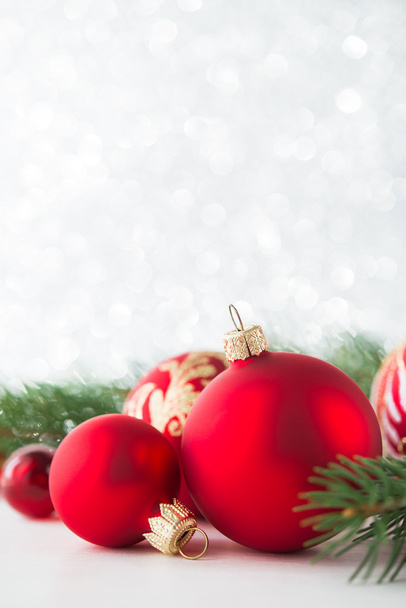 Adornos rojos y árbol de Navidad en el fondo de las vacaciones de brillo. Feliz tarjeta de Navidad. Tema de invierno. Feliz Año Nuevo
.  - Foto, imagen