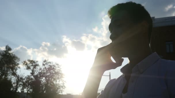 Puhuminen puhelimessa, auringon edessä auringonlaskun aikana, Siluetti
 - Materiaali, video