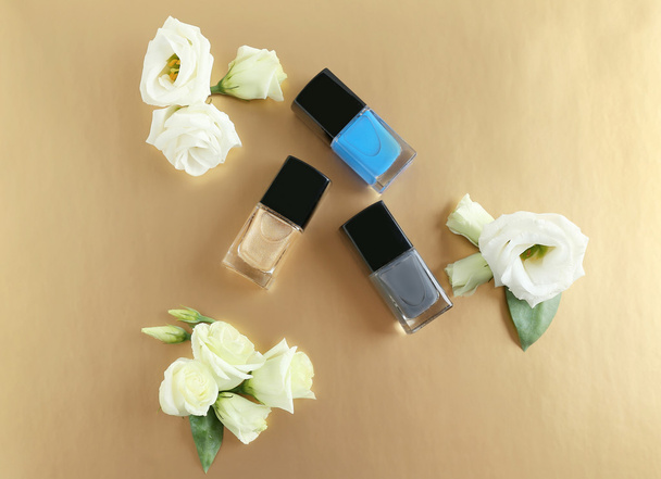 Nail polish and flowers on beige - Foto, afbeelding