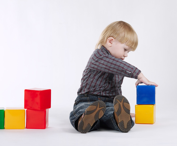 little boy plays with colorful cubes - Фото, зображення