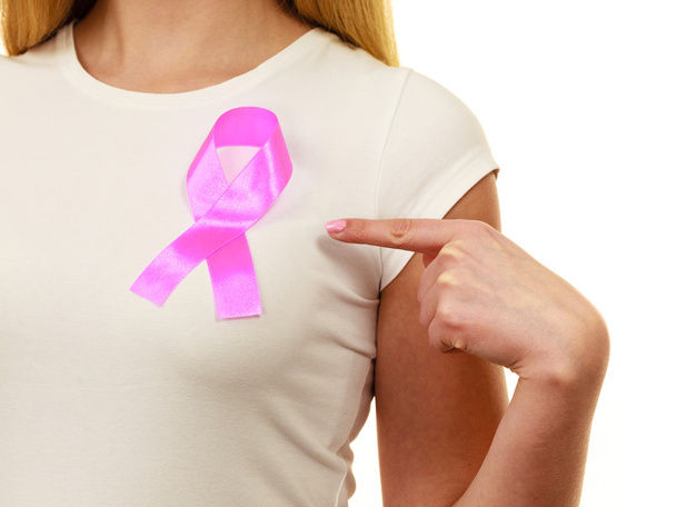 Closeup pink cancer ribbon on woman chest  - Photo, Image