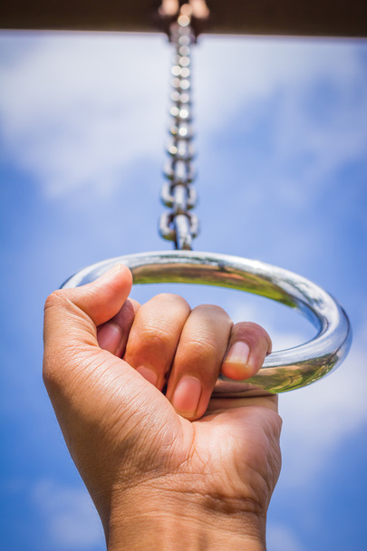 hand in metal chains against the blue sky. - Photo, Image