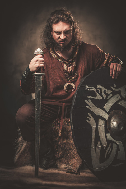 Enojado vikingo con espada en una ropa de guerrero tradicional
 - Foto, Imagen