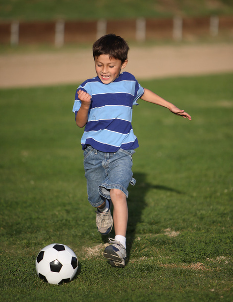 Latino boy playing with soccer ball - Fotó, kép