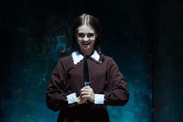 Portrait of a young girl in school uniform as killer woman - Foto, Imagen
