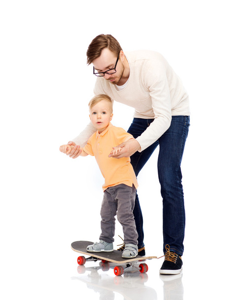 happy father and little son on skateboard - Foto, imagen