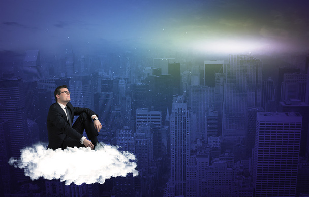Homme assis sur un nuage au-dessus de la ville
 - Photo, image