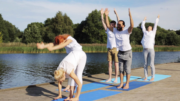 gruppo di persone che fanno esercizi di yoga all'aperto - Filmati, video