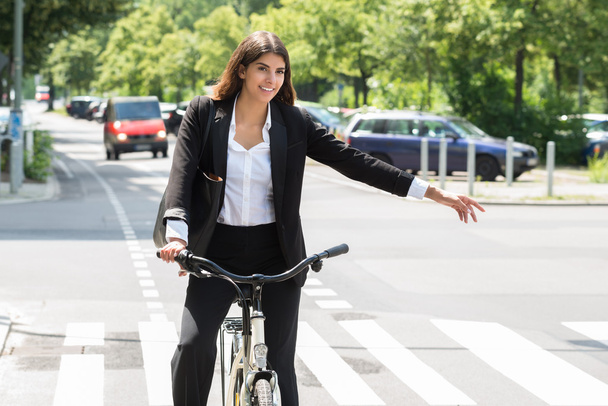 Young Businesswoman Showing Turn On Bicycle - Zdjęcie, obraz