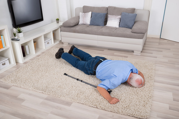 Nieprzytomnego człowieka osób niepełnosprawnych, leżąc na dywanie - Zdjęcie, obraz