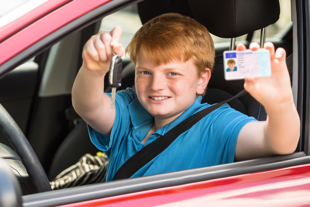 Ευτυχισμένο παιδί κάθεται μέσα στο αυτοκίνητο - Φωτογραφία, εικόνα