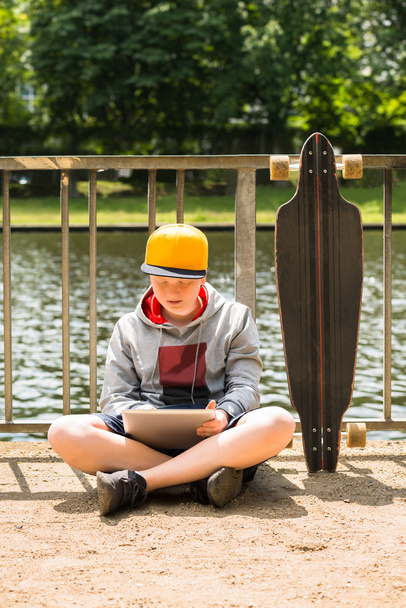 Boy Wearing Cap Using Digital Tablet - 写真・画像