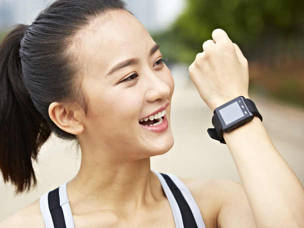 young asian woman answering a call using wearable device - Photo, Image
