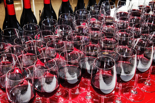 ποτήρια και μπουκάλια κόκκινο κρασί στο τραπέζι κοκτέιλ πάρτι - Φωτογραφία, εικόνα