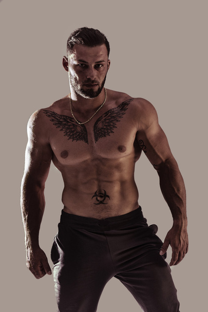 Handsome topless muscular man standing - 写真・画像