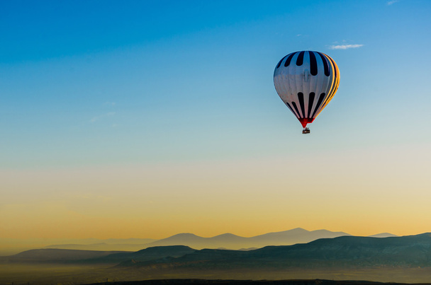 Balão de ar quente sobrevoando paisagem rochosa olcânica, Capadócia
, - Foto, Imagem