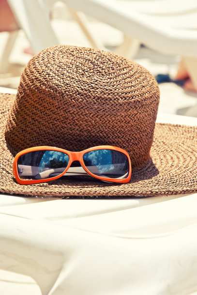 Chapéu de palha com óculos de sol na longue
 - Foto, Imagem