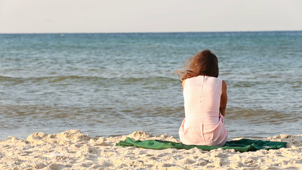 lány ül a strandon - Felvétel, videó