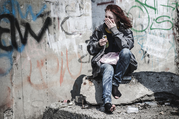 muchacha joven en ropa vieja sucia andrajosa, sin zapatos sentados en un ro
 - Foto, Imagen