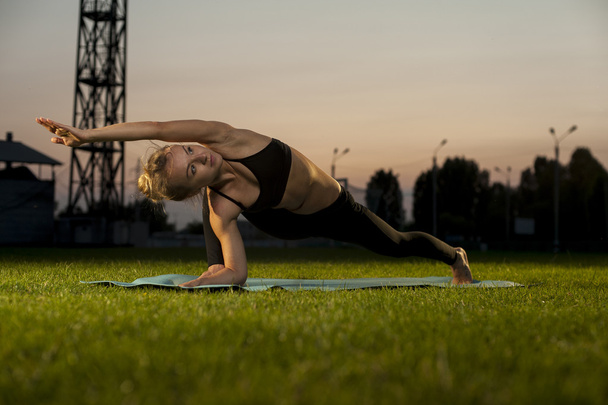Νέος ευέλικτος γιόγκα γυναίκα εξάσκηση σε εξωτερικούς χώρους - Φωτογραφία, εικόνα