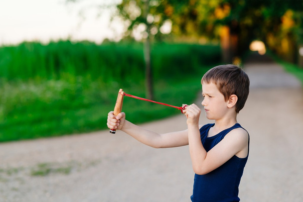 Мальчик играет с рогаткой
 - Фото, изображение