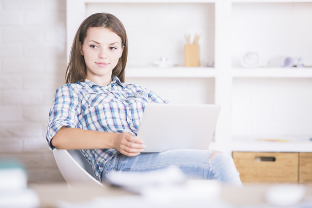 Thinking young woman with laptop - Фото, изображение