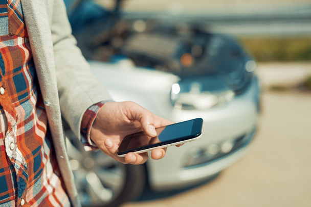 Uomo che utilizza smartphone dopo un incidente stradale
 - Foto, immagini