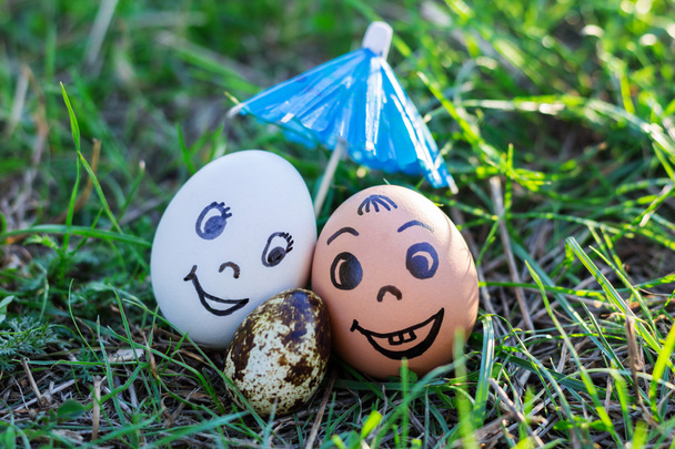 Funny eggs imitate smiling mixed couple with versicolored baby - Photo, Image