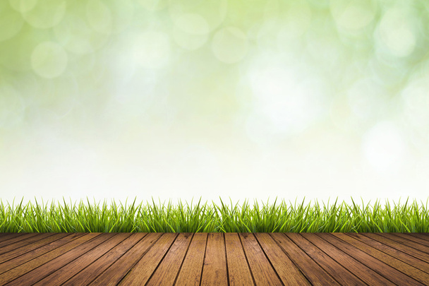 Houten vloer, gras en groen onscherpe achtergrond - Foto, afbeelding
