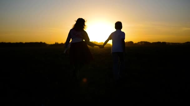 der Junge mit dem Mädchen auf der Flucht in den Sonnenuntergang - Filmmaterial, Video