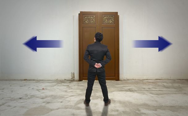 Επιχειρηματίας που στέκεται σε αμφιβολία την ξύλινη πόρτα  - Φωτογραφία, εικόνα