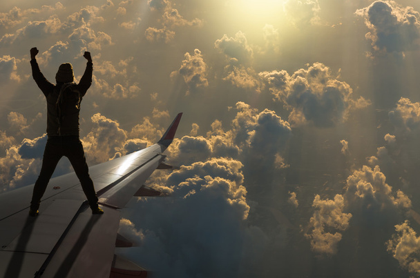силует людини на крилі літака
  - Фото, зображення