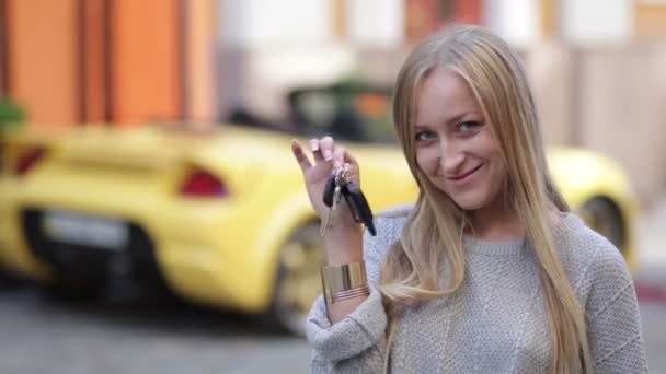 Jovem mulher sorridente segurando chaves para carro novo
 - Filmagem, Vídeo