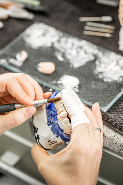 Woman hand painting denture - Fotoğraf, Görsel
