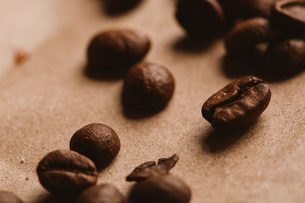 granos de café oscuro primer plano sobre papel ligero
 - Foto, imagen