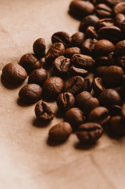 темные кофейные зерна крупным планом на светлой бумаге
 - Фото, изображение