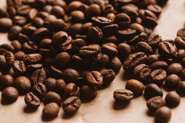 темные кофейные зерна крупным планом на светлой бумаге
 - Фото, изображение