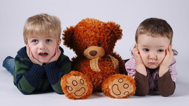 children and red bear on bright background - Fotografie, Obrázek