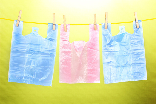 Cellophane bags hanging on rope on green background - Foto, immagini