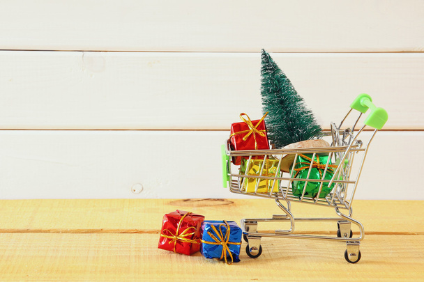 Shopping cart with christmas tree and presents - Фото, зображення
