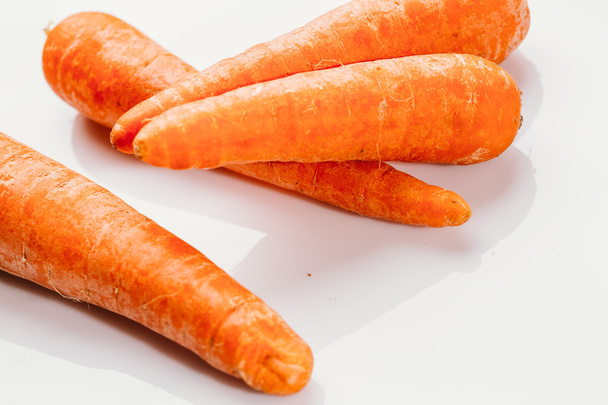 Zanahorias frescas crudas sobre un fondo blanco
 - Foto, imagen