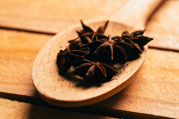 star anise spice in a wooden spoon on light background - Photo, Image