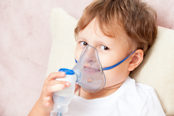Boy making inhalation with a nebulizer at home - Foto, afbeelding