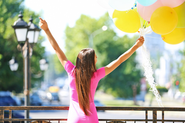 girl with balloons on street - Φωτογραφία, εικόνα