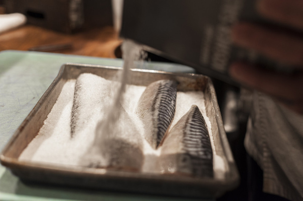 寿司シェフは、塩と魚にスパイスを追加します.  - 写真・画像