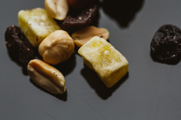 Mischung aus Nüssen und Trockenfrüchten auf dunklem Hintergrund - Foto, Bild