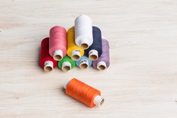 Bobbins threads multicolored. Old sewing tools on the wooden background. - Photo, Image