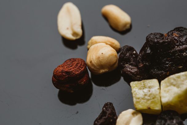 mixture of nuts and dried fruits on a dark background - Photo, Image