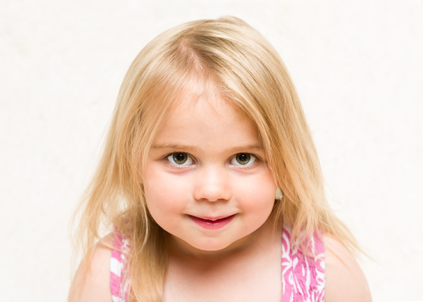 Portrait of beautiful blonde toddler baby girl with cheeky grin - Photo, Image