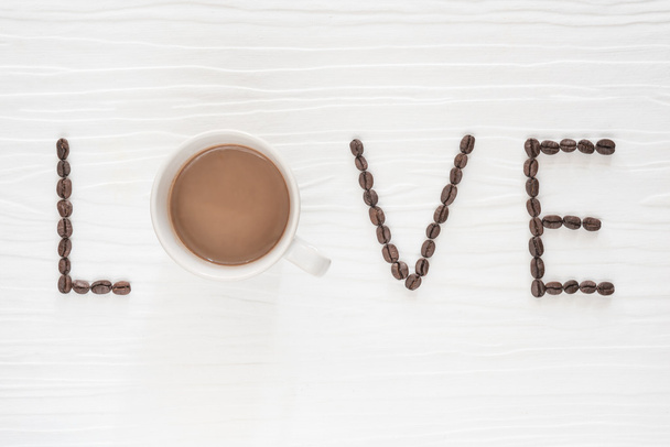 木製テーブルの上のコーヒー カップとコーヒー豆。コーヒーの愛の概念 - 写真・画像